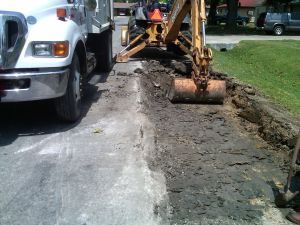 Backhoe digging on road