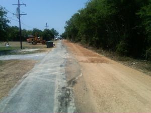 Dirt road with construction equipment in the distance